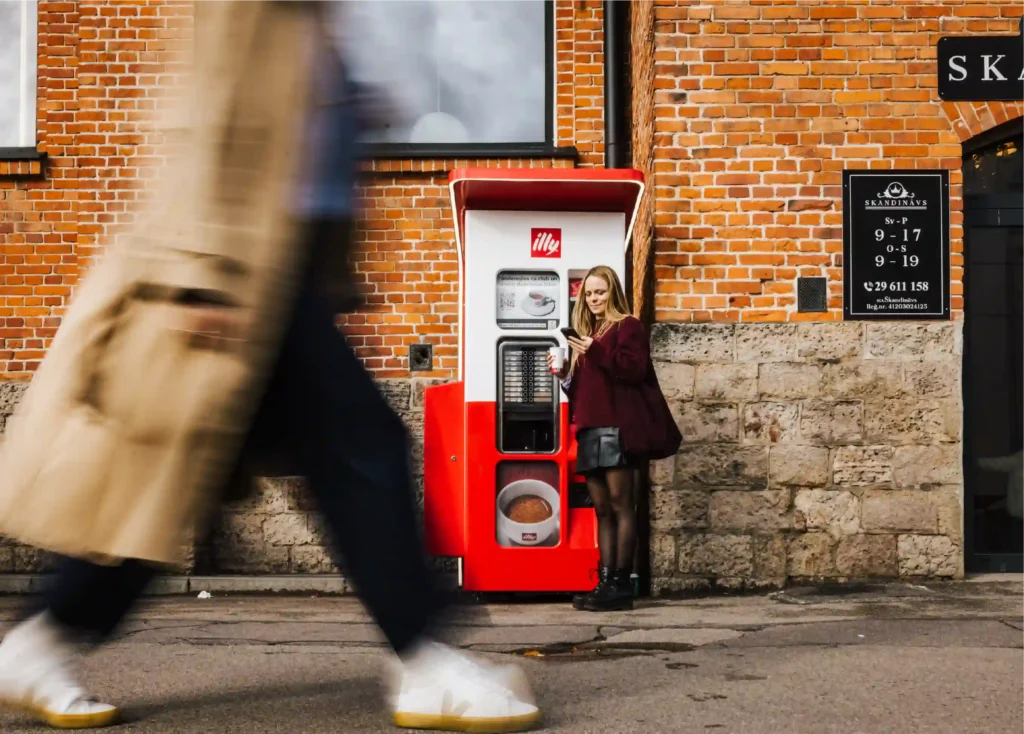 Customer paying with a phone at a vending machine card reader