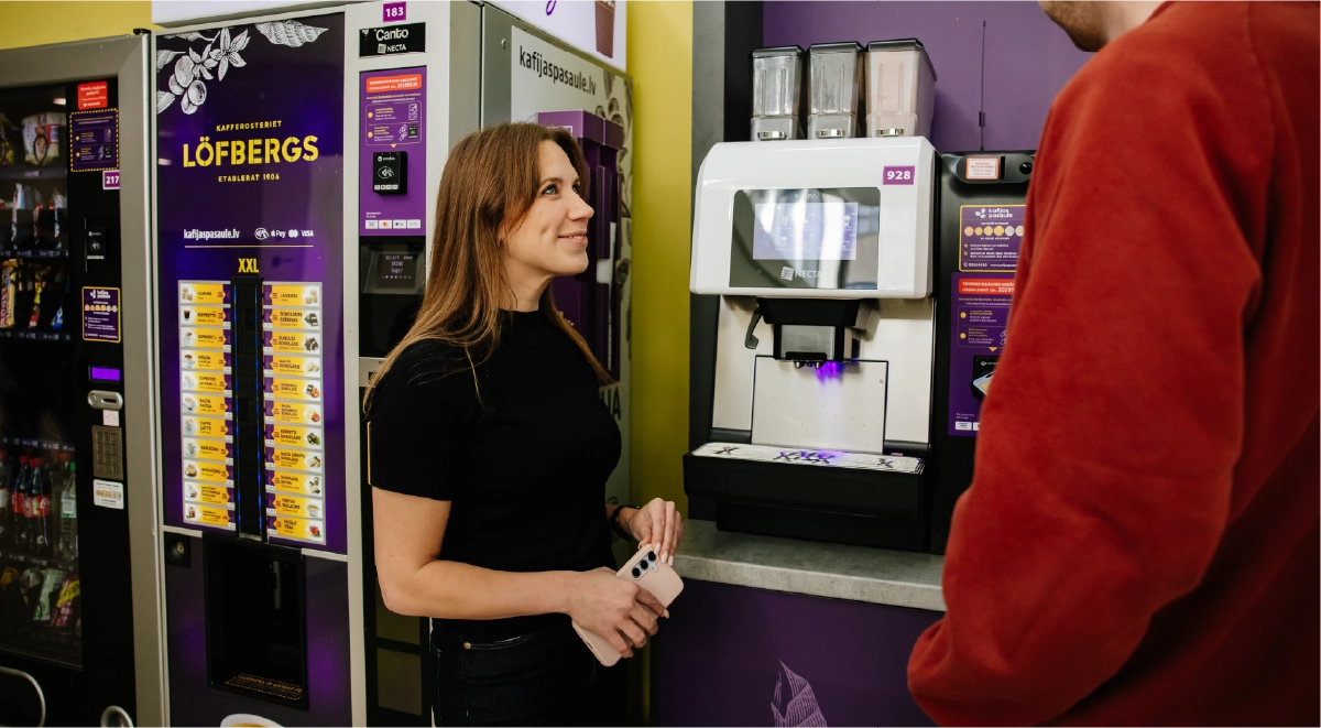 People stnading next unattended retail vending and coffee machine