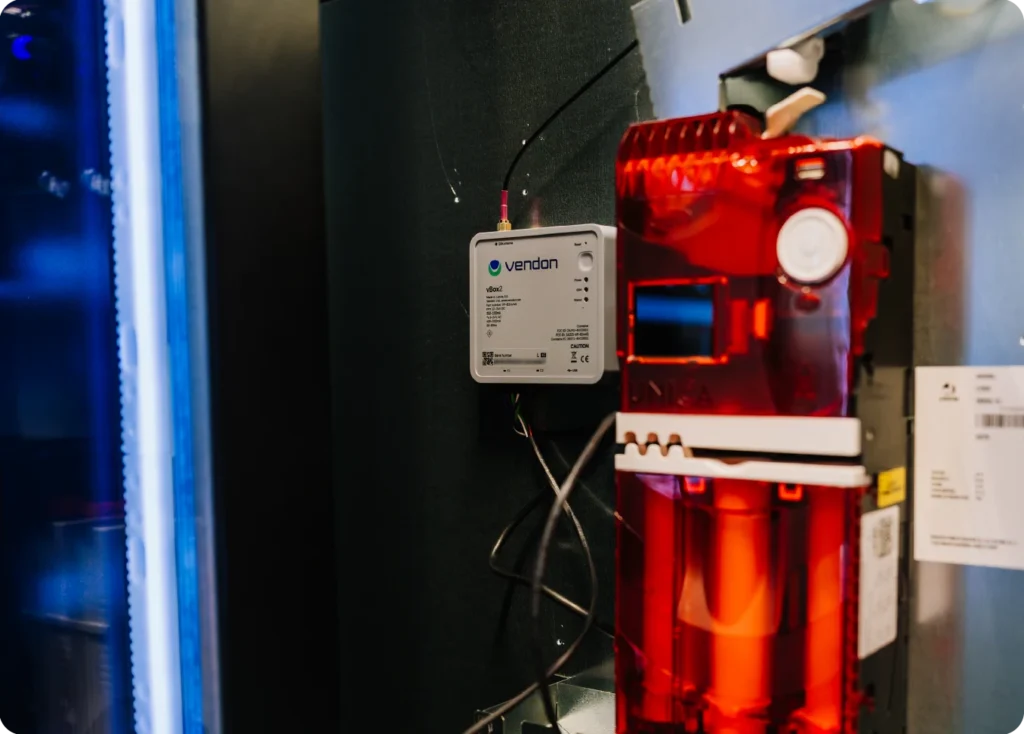 Vendon vBox2 telemetry device installed inside a Geile vending machine next to a Coges coin changegiver